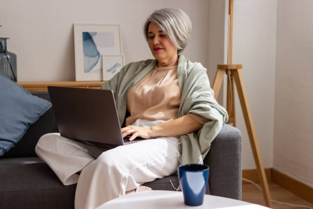 istock Mature woman working on laptop at home 2152294731
