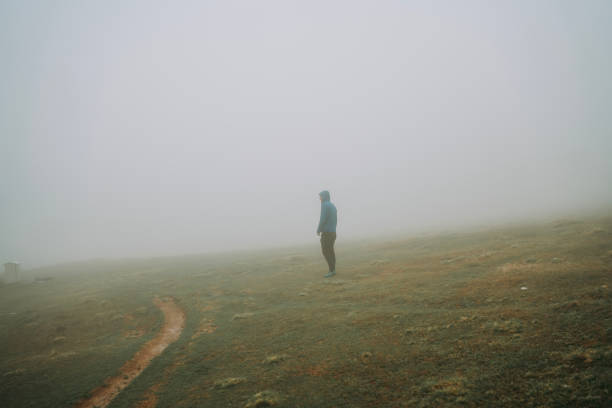 istock Man walking away on misty road. 2152295683
