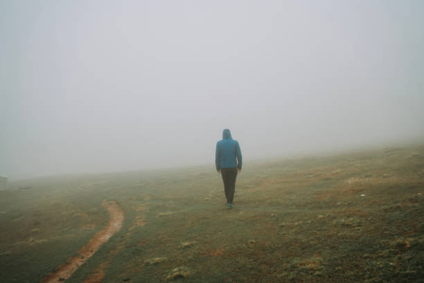 istock Man walking away on misty road. 2152296241