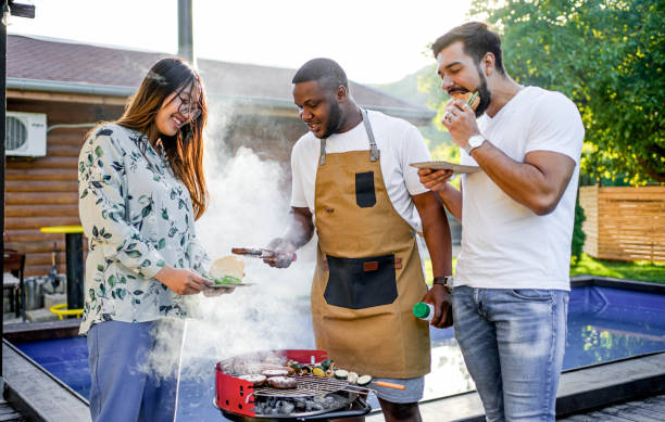 istock Young man barbecuing meat for friends 2152296550
