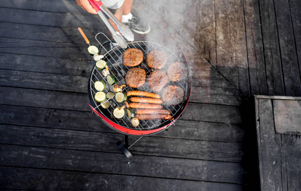 Man barbecuing meat and vegetables outdoors