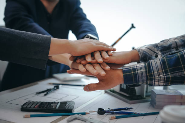 istock A skilled team of engineers collaborates in meetings, drafting blueprints for condos, apartments, and houses. Negotiating costs, bids, and contracts, they ensure efficient cooperation on construction sites. 2152298791