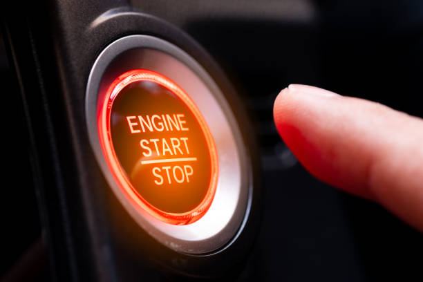 The driver's hand is pressing the car start button. Concept of transportation and technology