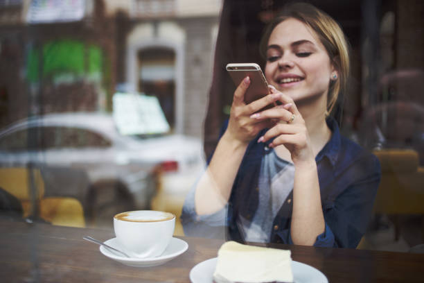 istock Woman with phone in hands chatting breakfast in a cafe 2152305025