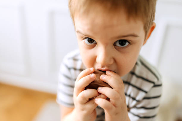 istock Cute little boy eating chocolate 2152306766