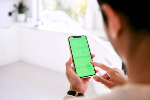 istock Rear view of a man holding his green screen phone 2152307741