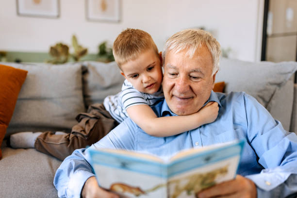 istock Grandfather and grandson bonding while reading book at home 2152307988