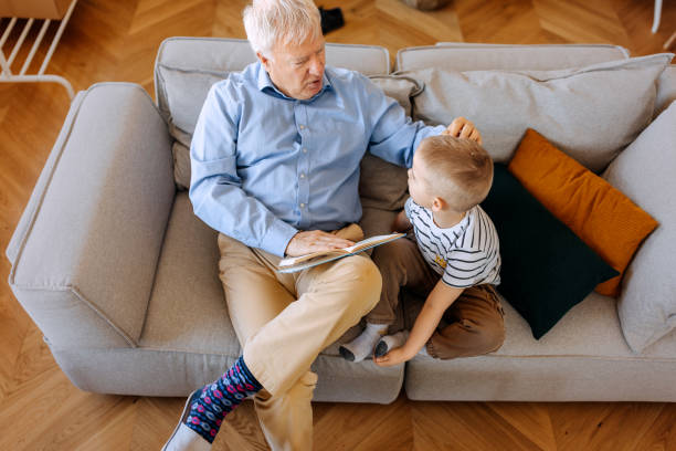 istock Grandfather and grandson bonding while reading book at home 2152308025