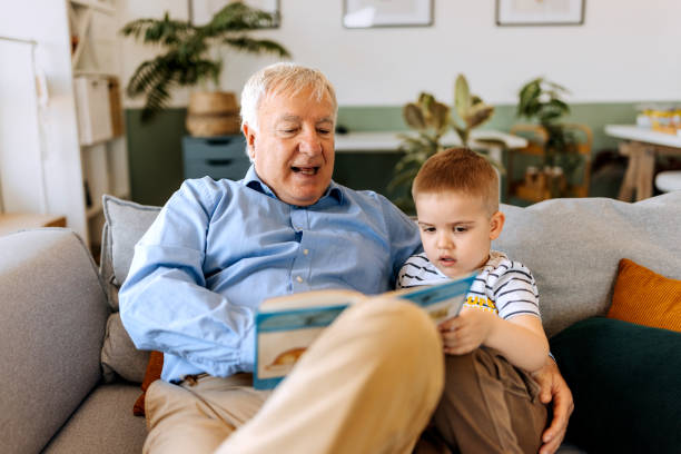 istock Grandfather and grandson bonding while reading book at home 2152308082
