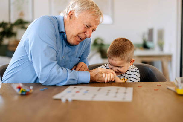 istock Grandfather and grandson having fun while playing board game at home 2152308443
