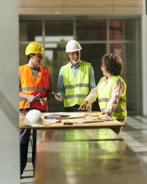 istock Happy inspectors and manual worker talking about plans in construction building. 2152308828