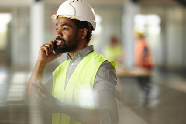 istock Black civil engineer talking on mobile phone in a hallway. 2152309154