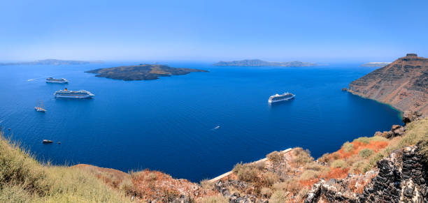 Discovering the Greek islands: horizon sea with cruise ship and the typical caldera of Santorini.