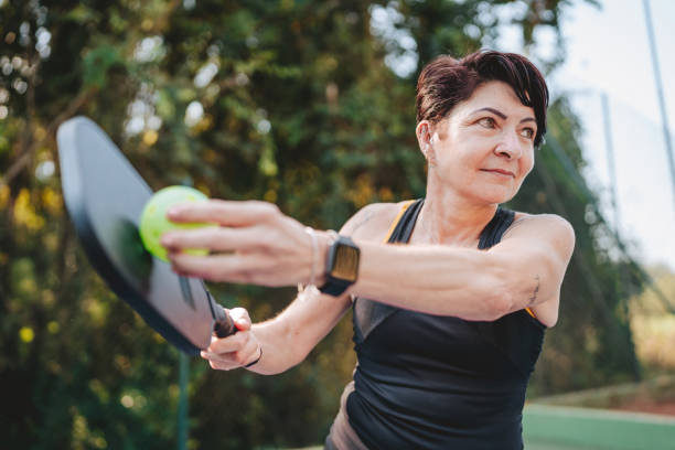 Woman serving in pickleball game