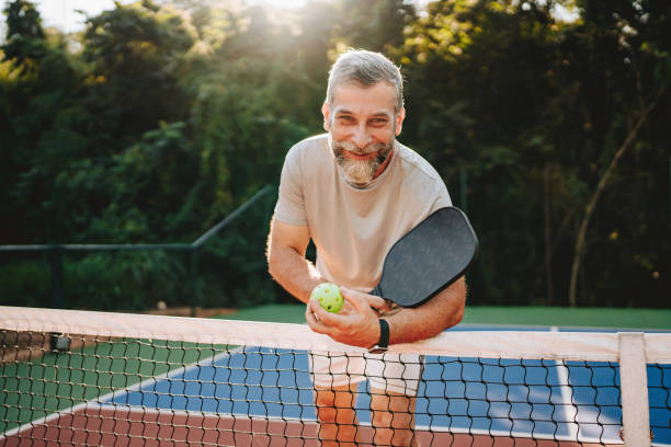 istock Portrait senior man at pickleball net 2152316504