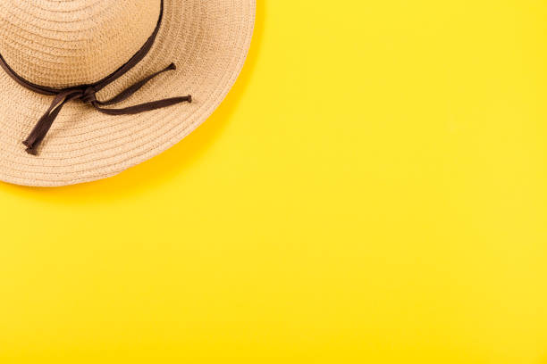 istock Top view on a retro straw hat on a yellow background. Summer concept. Minimalistic wallpaper for advertising a happy vacation on the sea or ocean or travel agency services with free place for text 2152316512