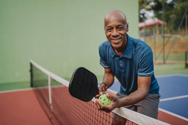 istock Man smiling at picklball net 2152316784