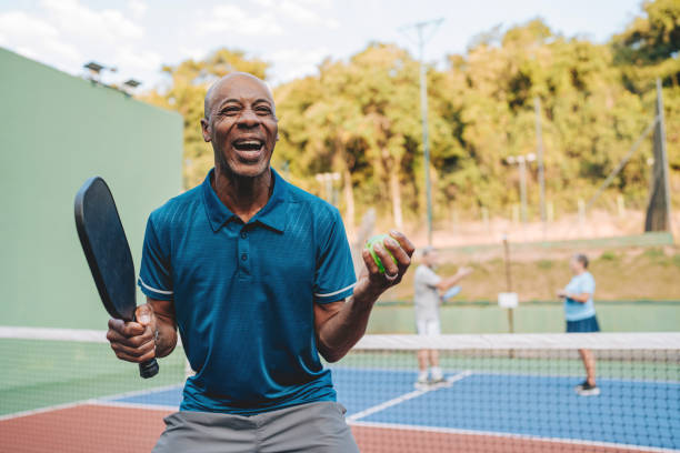 Mature man celebrates point in pickleball game