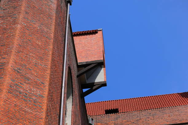 Red brick building top with a red metal object on the roof.
