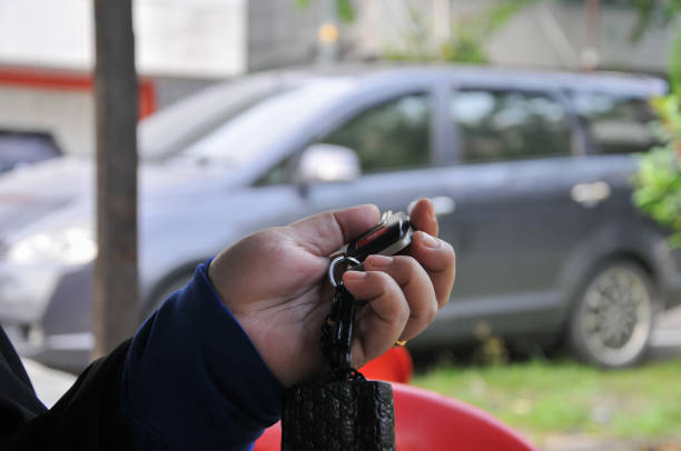 Riau-Indonesia, May 08th 2024 : hand holding key of car with bokeh background