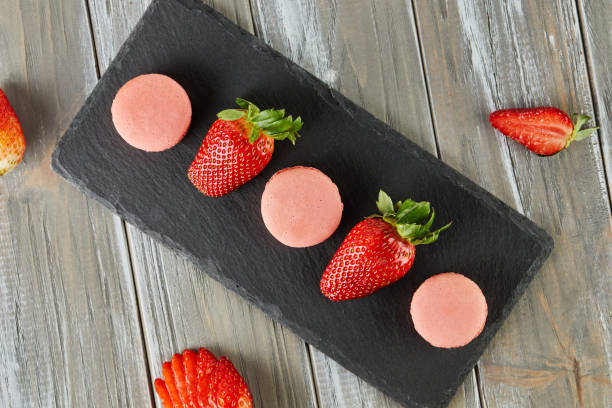 istock Fresh strawberries and macarons atop a blue tablecloth 2152322310