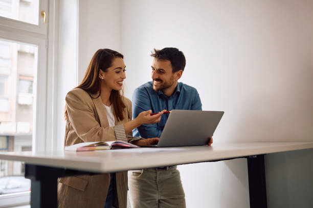 istock Happy colleagues cooperating while working on laptop in the office. 2152322514