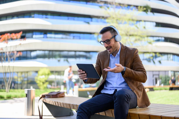 istock Young businessman gesturing and planning strategies over tablet on video call while sitting on bench 2152325739