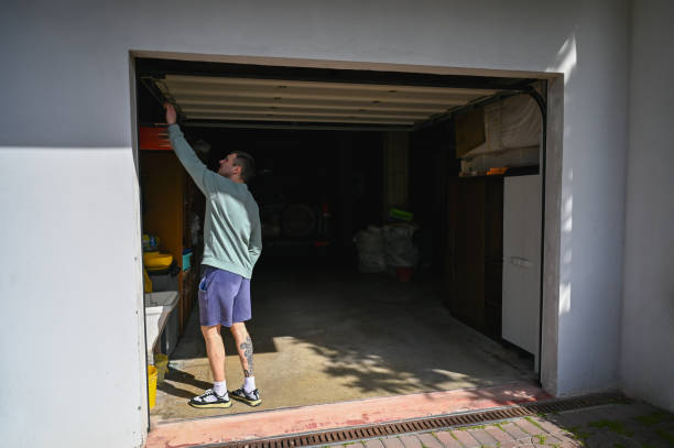 mann, der in der garage arbeitet. - rolltor stock-fotos und bilder