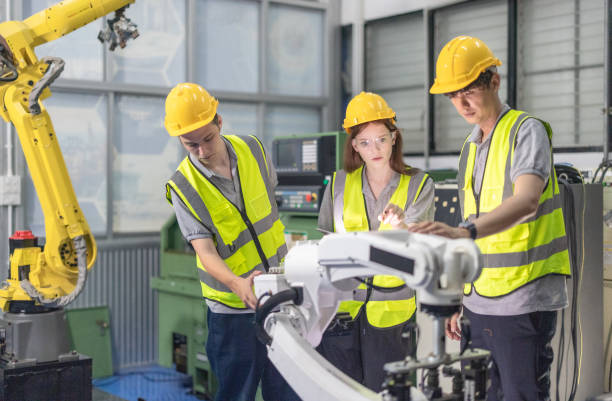 istock Trainees master robotics with hands-on workshops and quality control in manufacturing academy. 2152331276