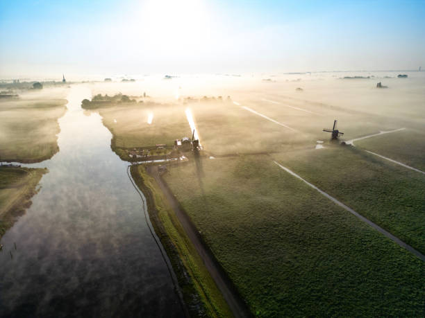 Dutch Windmill in the Mist along a Canal near Schermerhorn, Netherlands