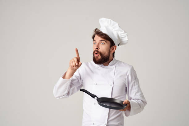 istock a man in a chef's uniform pan cooking kitchen isolated background 2152331871