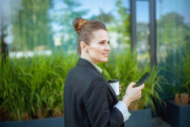 istock smiling woman worker near office building using smartphone 2152332238