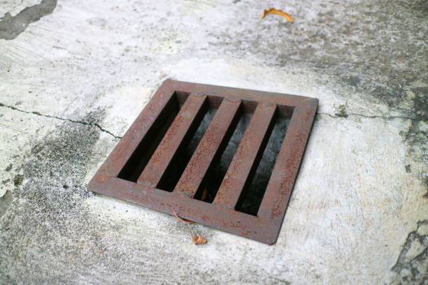 istock an iron gutter cover, with a rust color. Box shaped. on a concrete road 2152341805