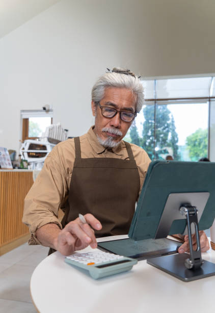 istock Senior owner calculating expenses for business 2152342320