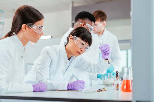istock Two scientists writing down notes on blue liquid in a test tube 2152342448