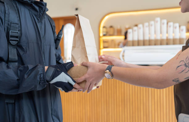 istock Asian delivery man pick up food from cafe 2152343543