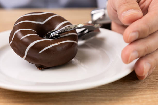 istock A man is handcuffed to a chocolate donut. Passion for sweets. 2152348356
