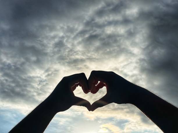 istock hands forming a love symbol in the sky 2152349696