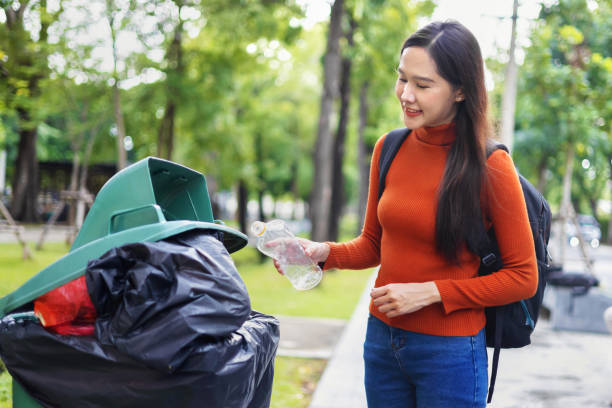 istock woman is throwing away trash and holding a bottle 2152351884