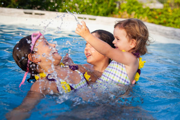 istock Joyful sisters playing in pool on sunny day 2152356415