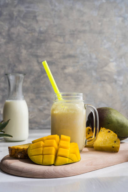 istock healthy mango and pineapple smoothie in a glass jar on a grey background 2152357060