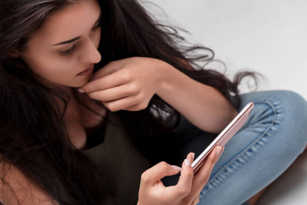 istock Focused, young woman uses smartphone, looks thoughtful 2152357370