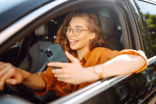 istock Young woman texting on her smartphone while driving a car. 2152360842