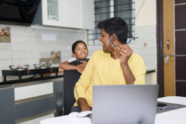 istock indian father and Daughter using laptop computer in kitchen at home office 2152362942