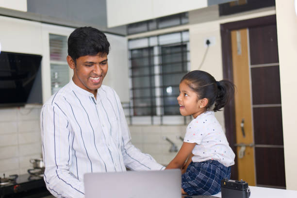 istock indian father and daughter using laptop computer in the kitchen at home 2152363001