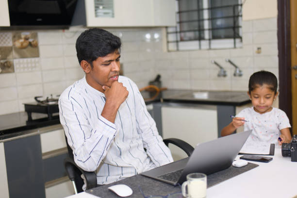 istock indian father and his daughter using laptop in the kitchen at home 2152363066