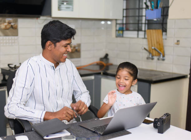 istock Indian Dad Helping Daughter with Schoolwork on Laptop in Kitchen 2152363085