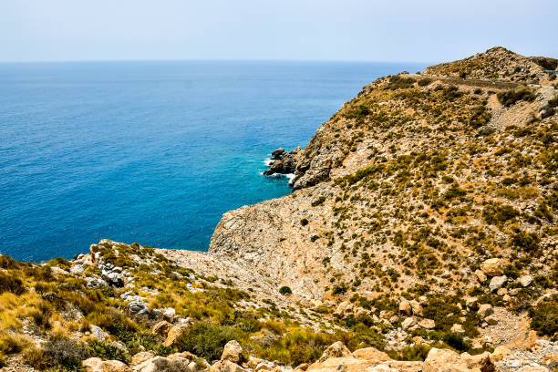 A rocky shoreline with a blue ocean in the background
