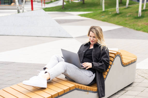 istock Young woman with laptop outside 2152376444
