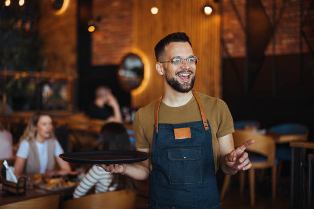 istock Young waiter serving coffee in a cafe 2152377078